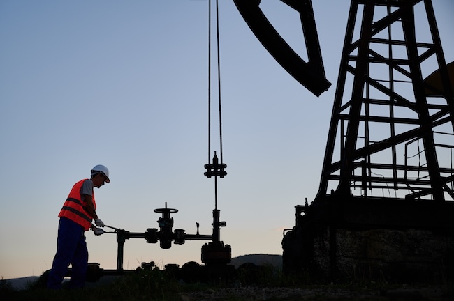 Oilfield professional working beside oil production equipment