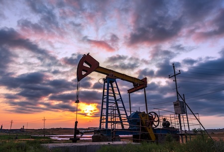Oil pumpjack silhouetted against the evening sky